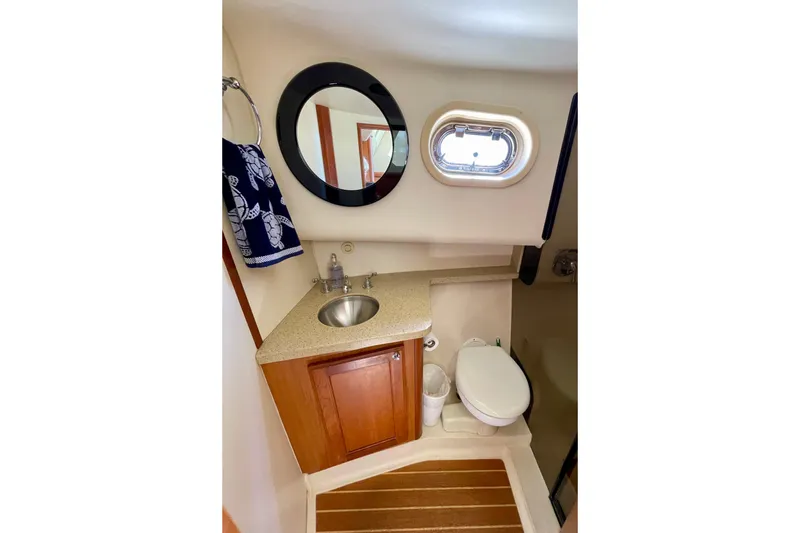 Slide: The Image of Compact bathroom in 2008 Mainship 34 Trawler with sink, toilet, and porthole window. - 54