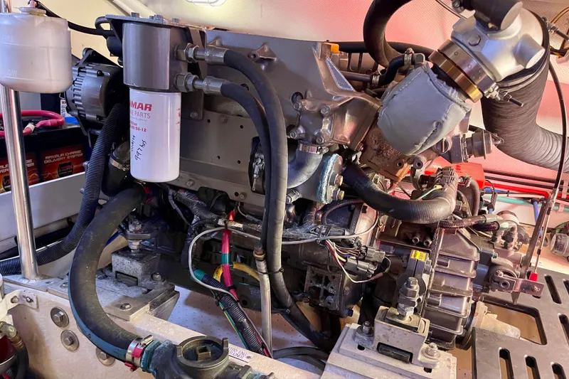 Slide: The Image of Engine compartment of a 2008 Mainship 34 Trawler, showcasing mechanical components and wiring. - 59