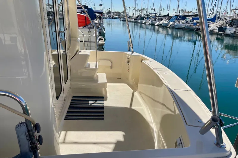 Slide: The Image of 2008 Mainship 34 Trawler deck view in marina, showcasing sleek design and spacious layout. - 6