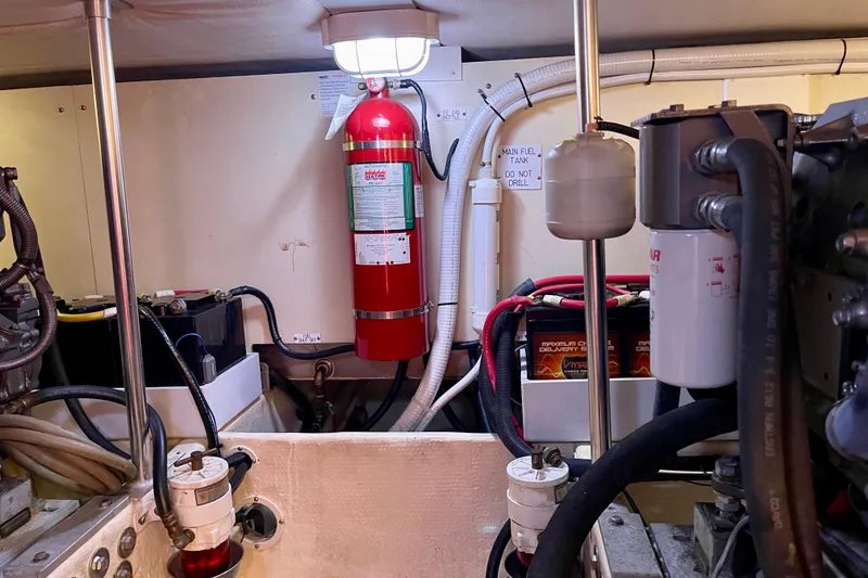 Slide: The Image of Engine room of 2008 Mainship 34 Trawler with fire extinguisher and mechanical components. - 60