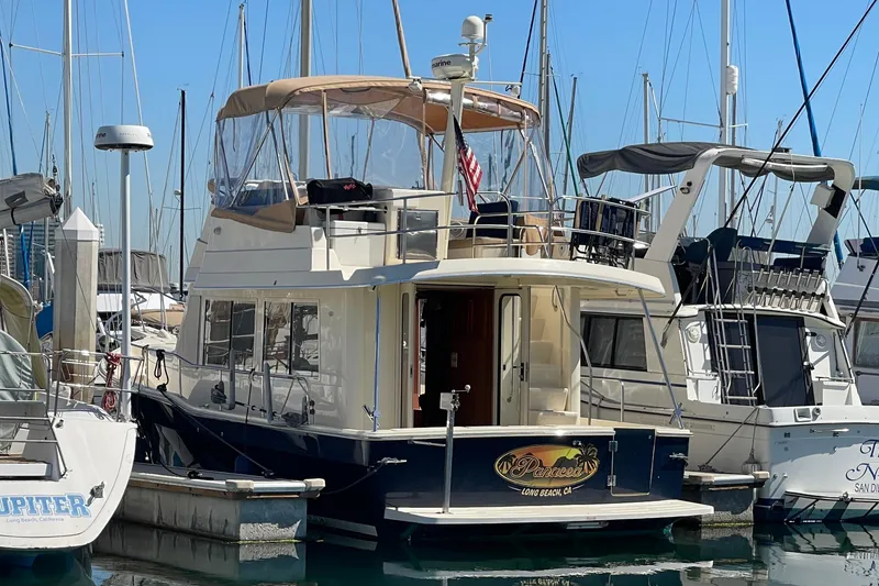 Slide: The Image of 2008 Mainship 34 Trawler docked at marina, featuring upper deck and enclosed cockpit. - 9