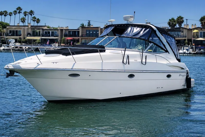 The Image of 2005 Cruisers Yachts 340 Express boat on water, with waterfront homes in background. - 0