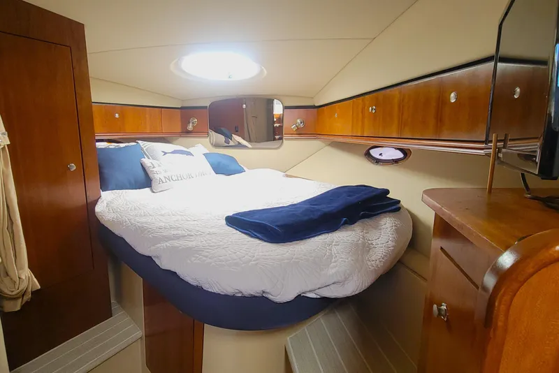 Slide: The Image of Luxurious cabin interior of 2005 Cruisers Yachts 340 Express with cozy bed and wooden cabinetry. - 11