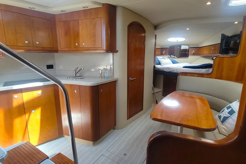 Slide: The Image of Luxurious 2005 Cruisers Yachts 340 Express interior with wood cabinetry and cozy seating area. - 12