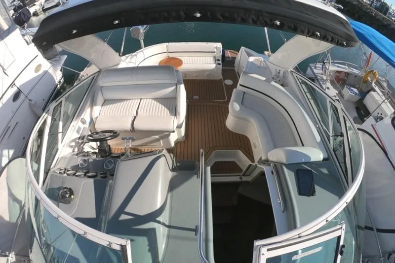 Slide: The Image of 2005 Cruisers Yachts 340 Express boat interior with seating and helm, docked at marina. - 17