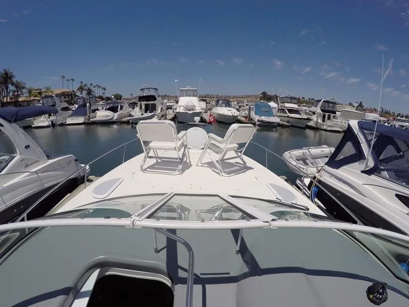 Slide: The Image of 2005 Cruisers Yachts 340 Express docked with deck chairs on deck. - 18