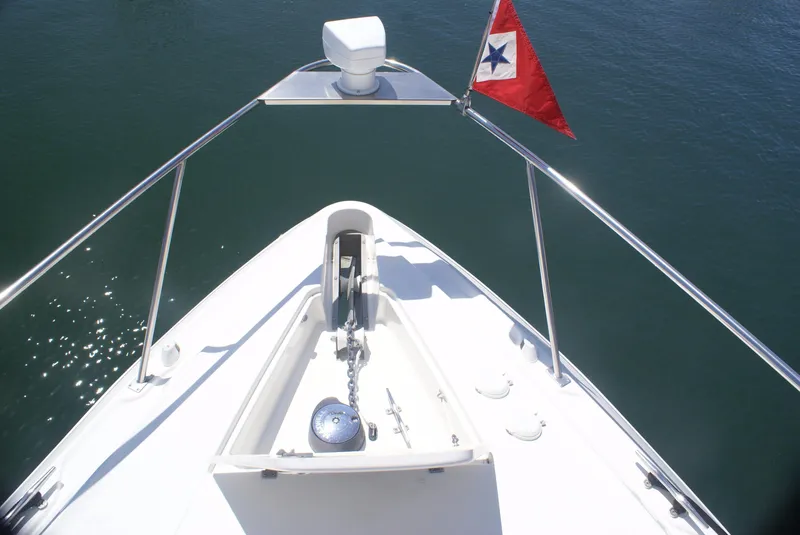 Slide: The Image of Bow view of 2005 Cruisers Yachts 340 Express with flag. - 19