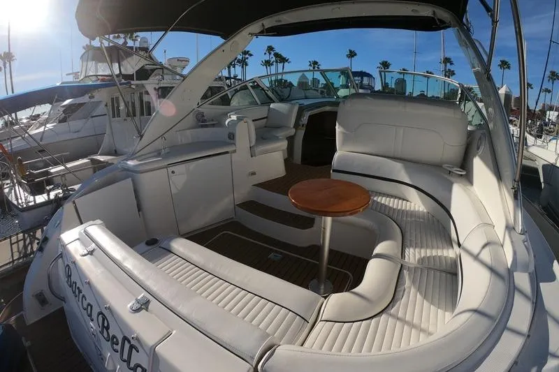 Slide: The Image of 2005 Cruisers Yachts 340 Express interior with white seating and wooden table. - 2