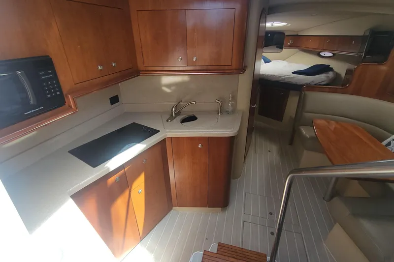 Slide: The Image of 2005 Cruisers Yachts 340 Express interior with kitchen, seating, and sleeping area. - 9