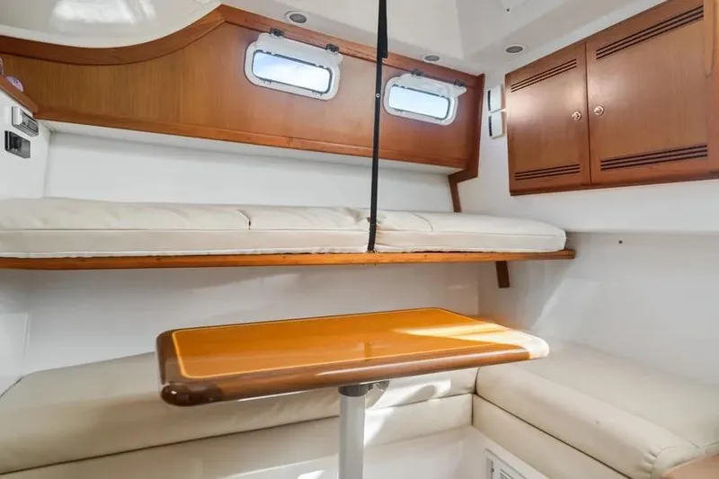 Slide: The Image of Interior of 2005 Cabo 35 Express boat with wooden table and cushioned seating. - 33