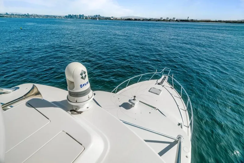 Slide: The Image of 2005 Cabo 35 Express yacht on open water with city skyline in background. - 40