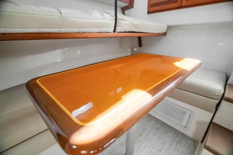 Slide: The Image of 2005 Cabo 35 Express interior with polished wooden table and cushioned seating. - 51