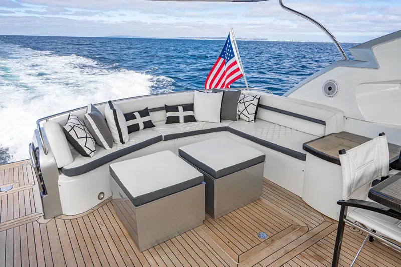 Slide: The Image of Luxurious Sunseeker Predator 68 yacht deck with elegant seating, ocean view, and American flag. - 7