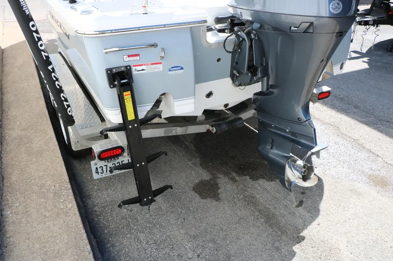 Slide: The Image of 2016 Sea Hunt BX 22 BR boat rear view with outboard motor and trailer. - 16