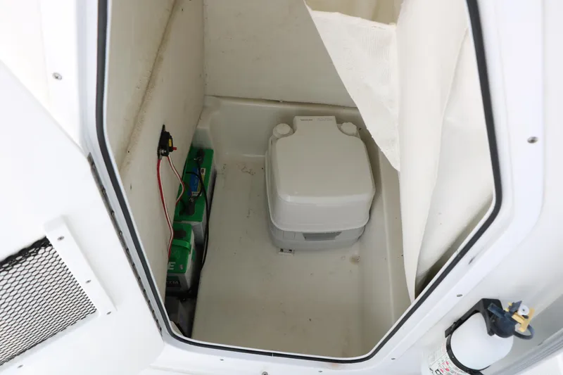 Slide: The Image of 2016 Sea Hunt BX 22 BR boat interior with portable toilet and battery compartment. - 28