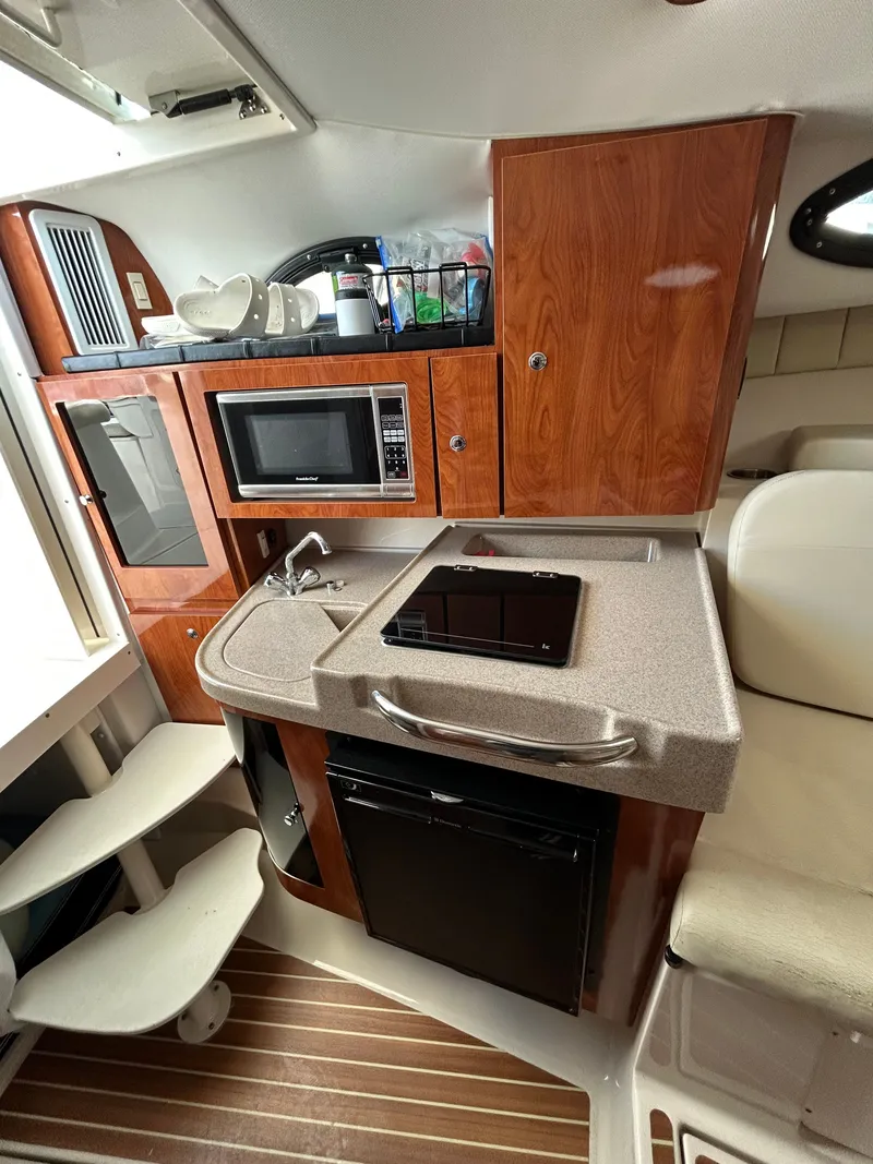 Slide: The Image of Interior of 2015 Wellcraft 290 Coastal with kitchenette and wood finish. - 13