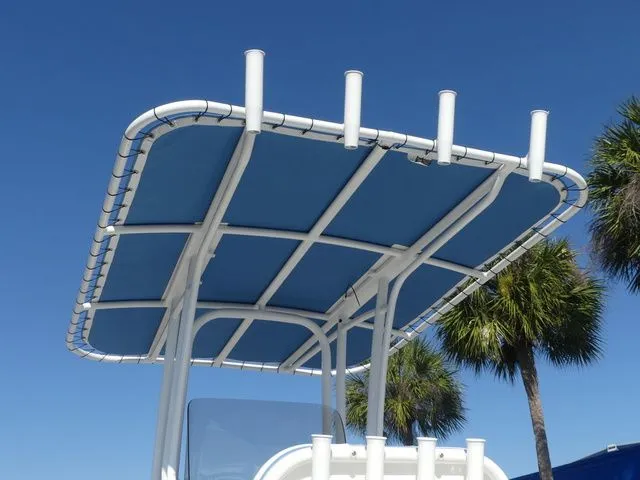 Slide: The Image of Robalo R180 Center Console 2026 with blue canopy and palm trees in background. - 20