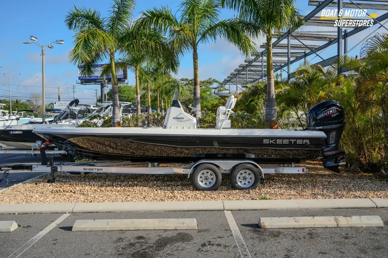 The Image of 2026 Skeeter SX230 boat on trailer, parked near palm trees at dealership. - 1