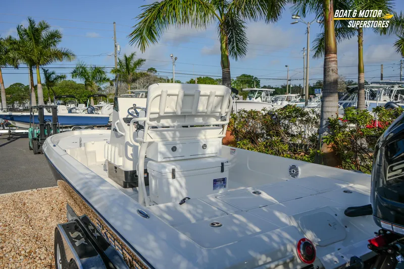 Slide: The Image of 2026 Skeeter SX230 boat displayed outdoors with palm trees and clear sky. - 20