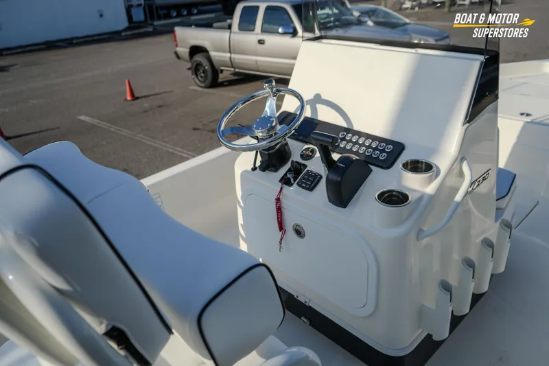 Slide: The Image of 2026 Skeeter SX230 boat console with steering wheel and controls in a parking lot. - 22