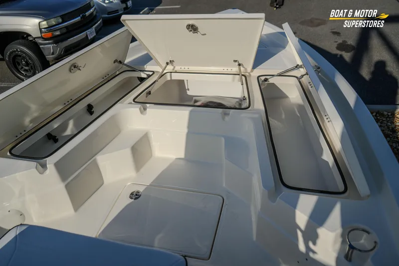 Slide: The Image of Open storage compartments on a 2026 Skeeter SX230 boat deck. - 24