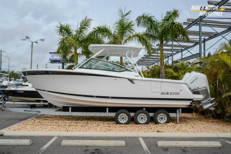 The Image of 2026 Blackfin 272 DC boat on trailer, parked outdoors near palm trees. - 1