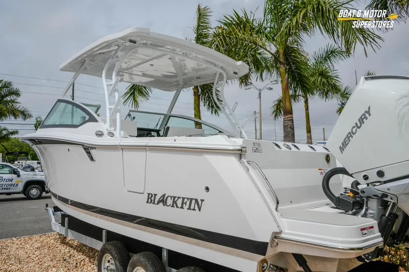 Slide: The Image of 2026 Blackfin 272 DC boat with Mercury engine, displayed outdoors near palm trees. - 12