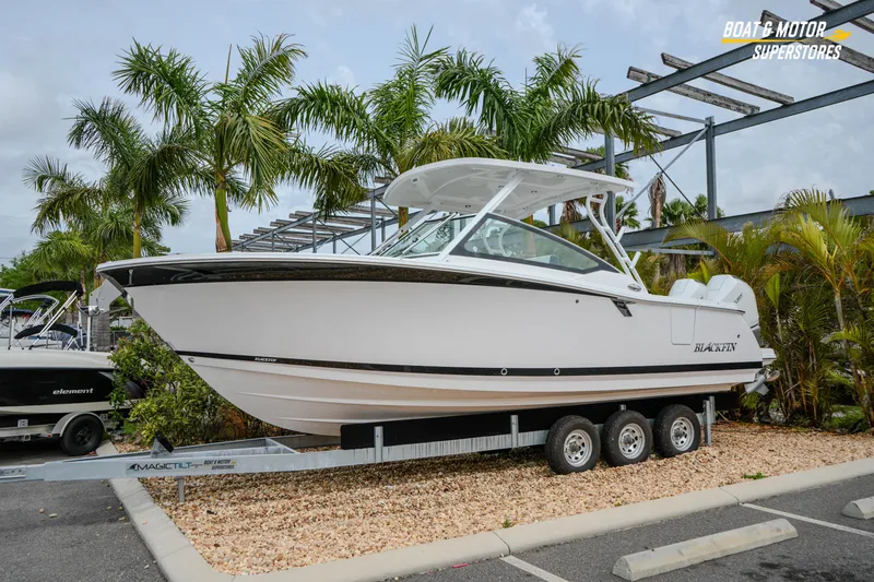 Slide: The Image of 2026 Blackfin 272 DC boat on trailer, surrounded by palm trees at dealership. - 3