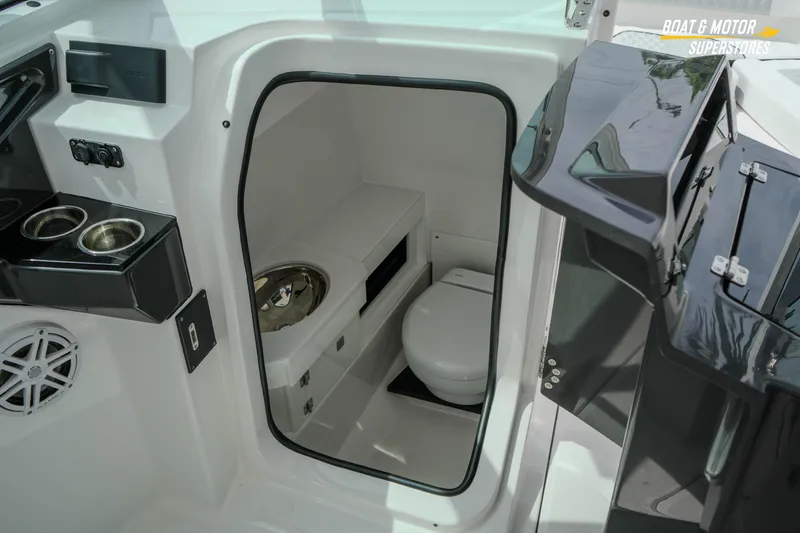 Slide: The Image of Interior of 2026 Blackfin 272 DC boat featuring a compact marine toilet. - 31