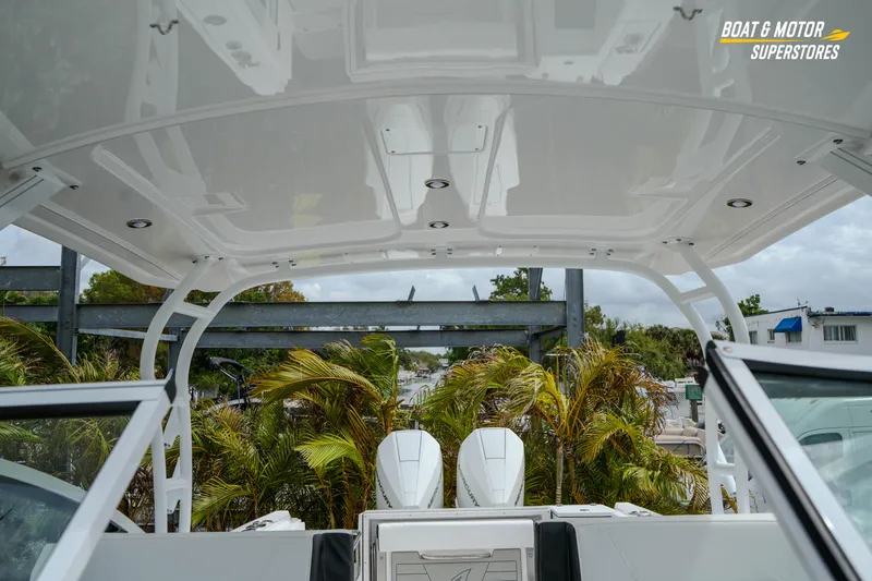Slide: The Image of 2026 Blackfin 272 DC boat interior with canopy and twin engines, surrounded by palm trees. - 40