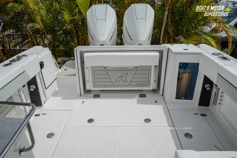 Slide: The Image of 2026 Blackfin 272 DC boat deck with dual Mercury engines and storage compartments. - 45