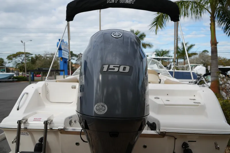 Slide: The Image of 2020 Key West 203 DFS boat with Yamaha 150 engine, parked outdoors. - 11