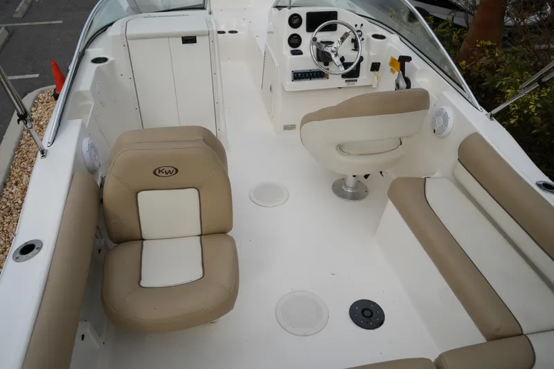 Slide: The Image of 2020 Key West 203 DFS boat interior with beige seating and steering console. - 16
