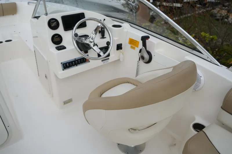 Slide: The Image of 2020 Key West 203 DFS boat cockpit with steering wheel and beige seating. - 21
