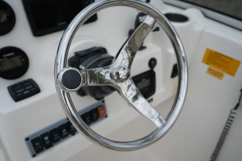 Slide: The Image of Steering wheel of a 2020 Key West 203 DFS boat, featuring control panel and gauges. - 28