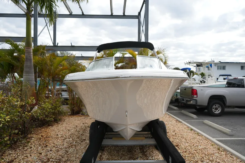 Slide: The Image of 2020 Key West 203 DFS boat on trailer, surrounded by palm trees and parked vehicles. - 3