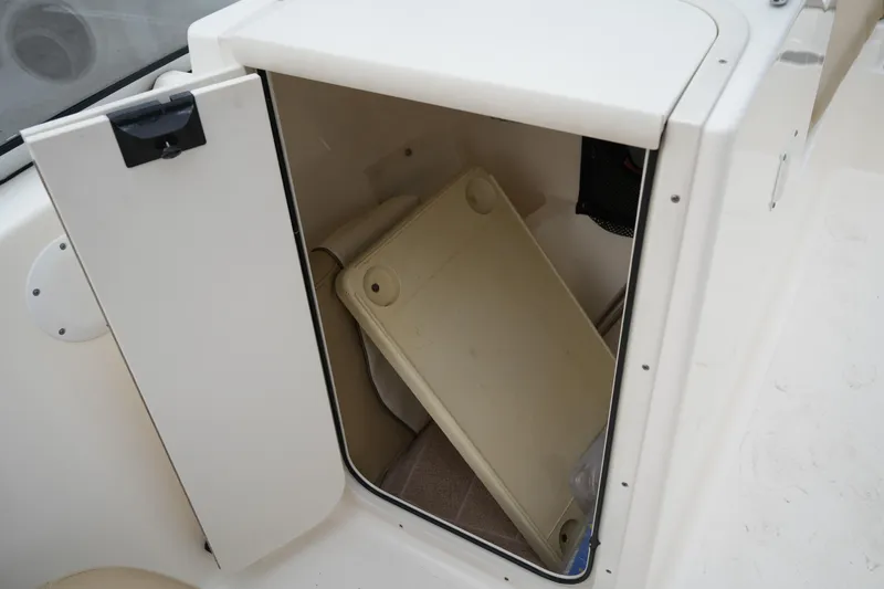 Slide: The Image of Storage compartment in a 2020 Key West 203 DFS boat, featuring a removable tray. - 43