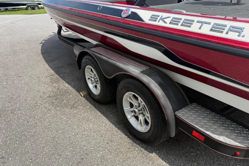 Slide: The Image of 2017 Skeeter ZX250 boat on trailer, featuring red and white design. - 6
