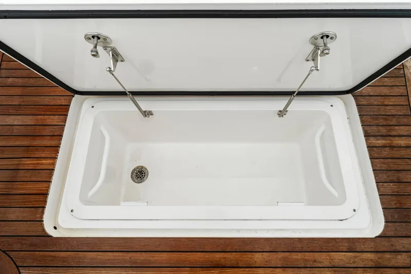Slide: The Image of Open storage compartment on 2018 Viking 44 Express boat with wooden deck. - 114