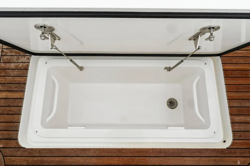 Slide: The Image of Open storage compartment on 2018 Viking 44 Express boat with wooden deck. - 115