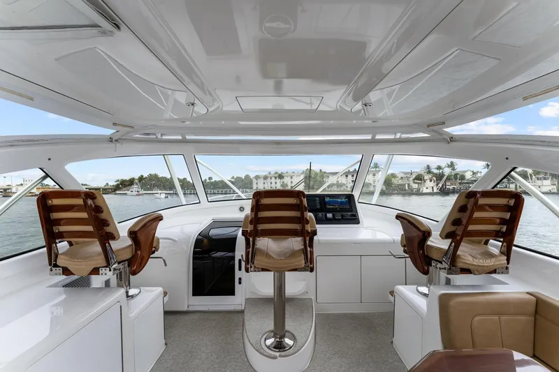 Slide: The Image of Interior view of 2018 Viking 44 Express yacht cockpit with three helm chairs. - 2