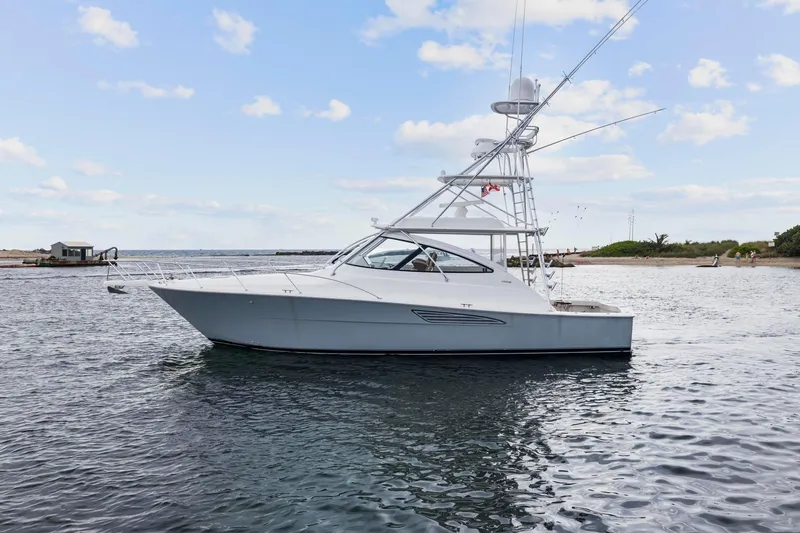 Slide: The Image of 2018 Viking 44 Express yacht on calm waters under a blue sky. - 28