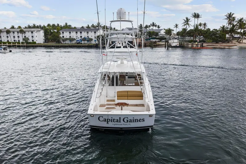 Slide: The Image of 2018 Viking 44 Express yacht on water, rear view, "Capital Gaines" name visible. - 30