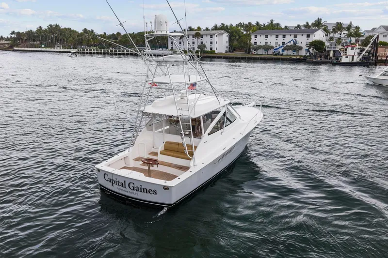 Slide: The Image of 2018 Viking 44 Express yacht cruising near a coastal town. - 31