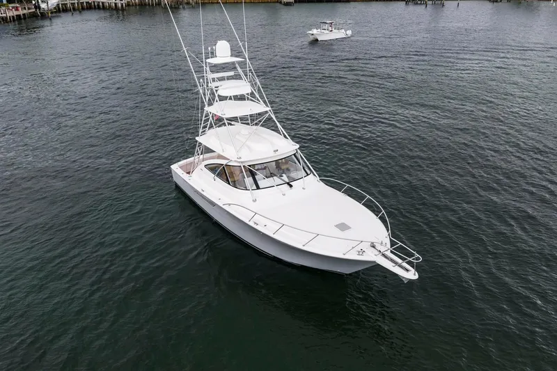 Slide: The Image of 2018 Viking 44 Express yacht on calm water, showcasing sleek design and tower. - 32