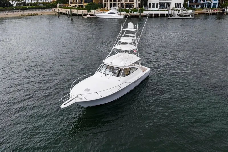 Slide: The Image of 2018 Viking 44 Express yacht on calm water near a dock. - 34