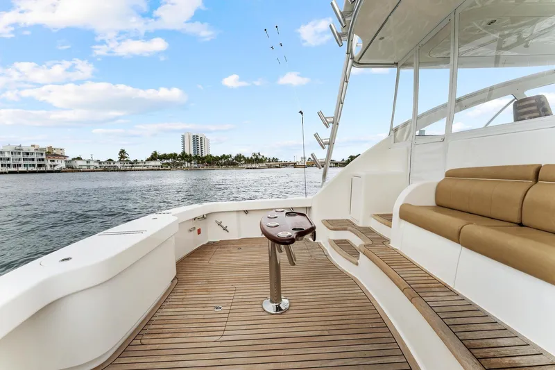 Slide: The Image of 2018 Viking 44 Express yacht deck with seating, overlooking waterfront buildings and palm trees. - 46