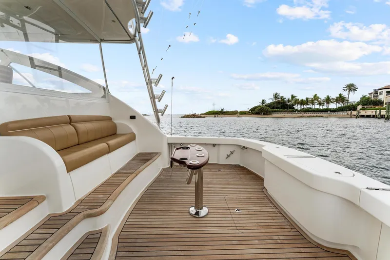 Slide: The Image of 2018 Viking 44 Express yacht deck with seating, ocean view, and palm trees in the background. - 47