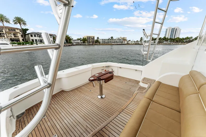 Slide: The Image of 2018 Viking 44 Express yacht deck with seating, overlooking waterfront homes and palm trees. - 51
