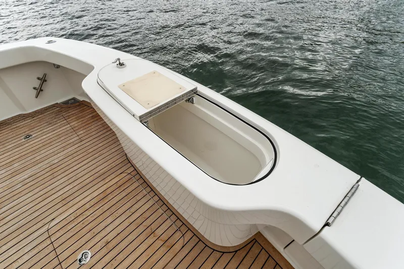 Slide: The Image of 2018 Viking 44 Express boat deck with open storage compartment by the water. - 57